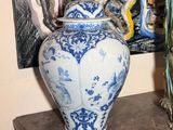 deux vases posés sur une table devant un tableau