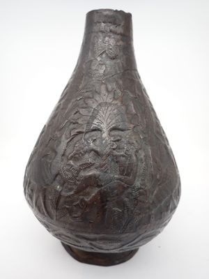 un vase brun posé sur une surface blanche