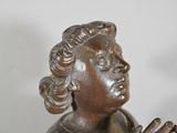 bronze statue of a woman holding a glass of wine in her hand