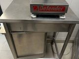 une table en acier inoxydable sur laquelle est posée une pancarte