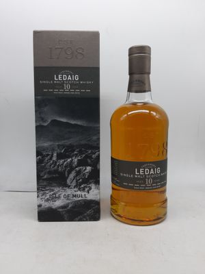 une bouteille de whisky posée sur une table à côté d'un coffret