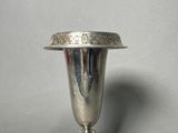 a silver vase that is sitting on a table