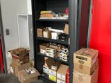 Des cartons, les uns empilés sur les autres, sont rangés sur une étagère dans un local de stockage