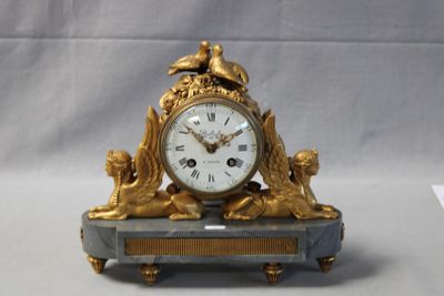a gold clock sitting on top of a marble table