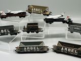 six wagons de train miniature exposés sur une table