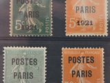four different postages of different colors and sizes in a display case