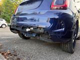 the rear end of a blue car parked in a parking lot