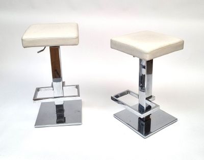 pair of chrome and leather bar stools with a white upholstered seat