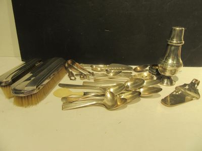 plein de cuillères en argent et une bouteille posées sur une table