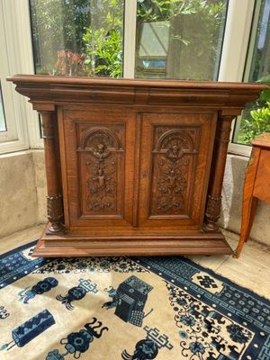 an old wooden cabinet sitting on top of a rug in front of a window