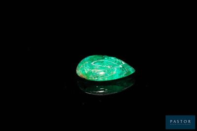 a close up of a green stone on a black surface