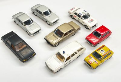 plusieurs petites voitures sont alignées sur une surface blanche