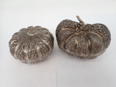 deux citrouilles argentées posées sur un fond blanc