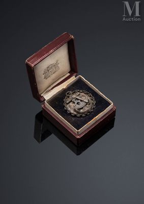 an image of a silver medal in a wooden box on a black surface