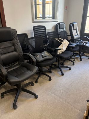 plusieurs chaises de bureau noires alignées dans une pièce dotée d'une fenêtre