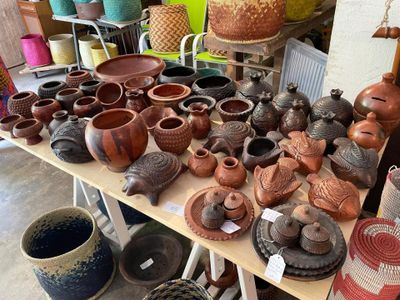 many different types of pottery displayed on a table