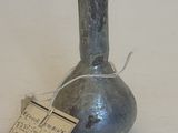 un petit vase en métal muni d'une étiquette