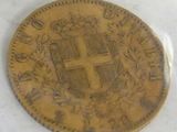 an old gold coin with a cross on it on a white surface