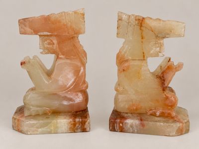 pair of carved bookends of a man and a woman sitting on a rock