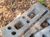 a pile of concrete blocks on the ground next to a wire fence