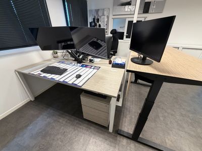 un bureau équipé de deux écrans et d'un clavier