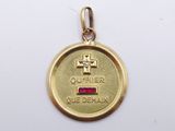 an image of a gold medal with a red stone in the center