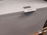 a white chest freezer sitting on a pallet in a warehouse