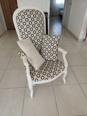 une chaise sur laquelle est posé un coussin, dans une pièce