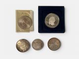 several coins are sitting in a black box on a white surface