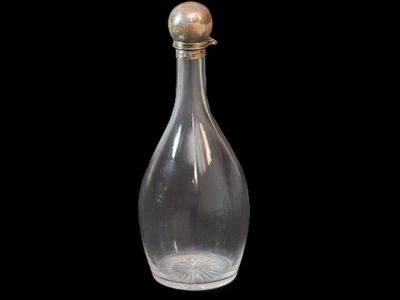une bouteille en verre transparent avec un bouchon doré sur fond noir