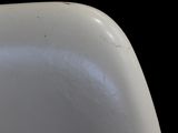 a close up of a white chair against a black background