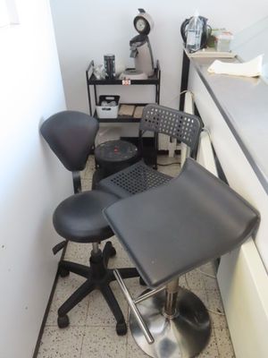une chaise noire et un tabouret noir dans un coin de la pièce