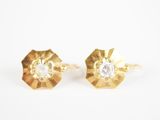 une paire de boucles d'oreilles en or et diamants sur fond blanc