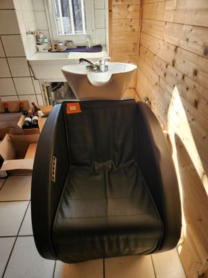 un fauteuil en cuir noir dans un coin d'une salle de bains