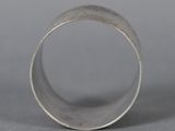 a close up of a silver ring on a gray surface