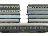 several model trains are lined up in a row on a white surface