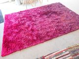 un tapis rose posé sur le sol du salon