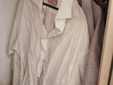 a white shirt hanging on a hanger in a closet