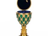 a close up of a gold and green goblet on a white background
