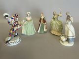 five figurines of people dressed in different costumes