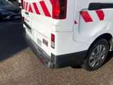 a white van with red and white stripes parked in a parking lot