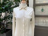 une chemise blanche posée sur un mannequin devant une porte