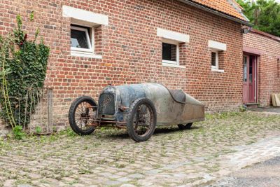an old car parked in front of a brick building