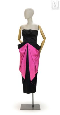 Le mannequin porte une robe noire et rose ornée d'un nœud rose.