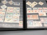 an open book with stamps on it sitting on top of a table
