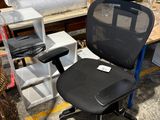 une chaise de bureau noire avec une assise noire dans une pièce