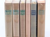 cinq livres sont alignés sur une surface blanche