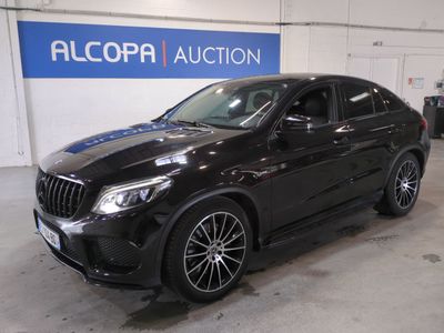 the mercedes gle is parked in a garage with a blue sign behind it