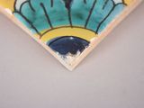 a close up of a tile with a blue and yellow design on it