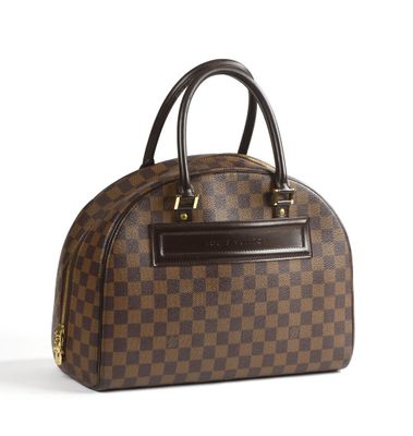 un sac à main marron et noir posé sur une surface blanche